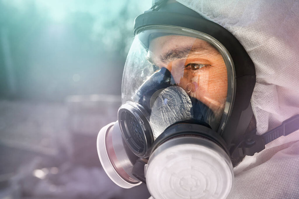 Homme portant un grand masque à gaz contre la contamination par le Coronavirus Covid-19. Lockdown for SARS-CoV2 virus pandemic. Spécialiste de la post-apocalypse respirant un masque anti-virus et radiogène. Vêtements Doomsday
 - Photo, image