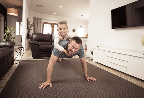 COVID-19 wyłączony. Szczęśliwy ojciec i córka ćwiczą razem podczas kwarantanny. Rodzina dobrze się bawiąca robiąc w domu aktywność fizyczną. Zostań w domu, Ćwiczenia, Zdrowie Samoopieka nad Coronavirus izolacji. - Zdjęcie, obraz