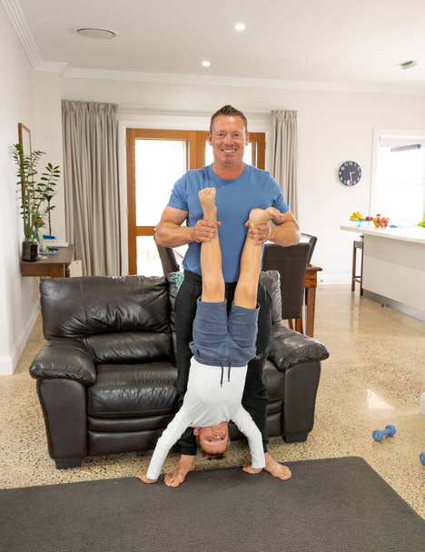 COVID-19 Shutdown. Father and son having fun exercising together and staying physically active at home during coronavirus quarantine. Stay home, Exercise, Health Self-care for Coronavirus isolation. - Photo, Image