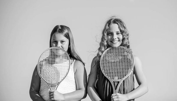 Relaxing after training. summer outdoor games. play tennis. childhood happiness. small girls with tennis racquet. summer sport activity. energetic children. happy and cheerful. sporty game playing - Foto, immagini