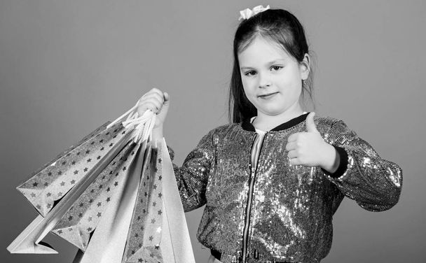 Shopping and purchase. Black friday. Sale discount. Shopping day. Child hold bunch packages. Kids fashion. Surprise gift. Great stores. Great choices. Girl with shopping bags violet background - 写真・画像