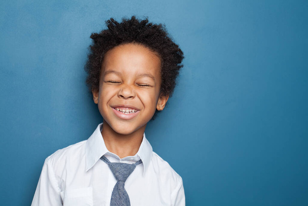 Kid laughing. Black child boy having fun on blue background - Photo, Image