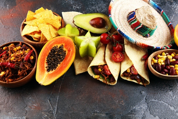 Mexikanische Speisen mischen sich in bunten Farben. Sombrero und mexikanisches Essen mit Tacos Tortillas - Foto, Bild