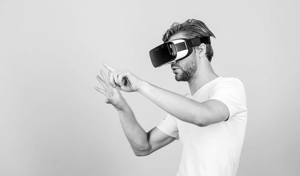 Virtual simulation. Man play game in VR glasses. Explore cyber space. Man hipster virtual reality headset on peach background. Entertainment and education. Virtual communication. Augmented 3D world - 写真・画像