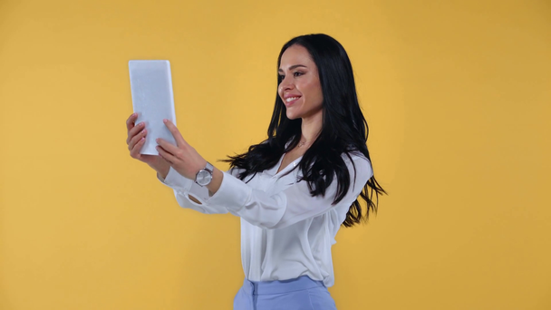Χαμογελαστή επιχειρηματίας που έχει βιντεοκλήση σε ψηφιακή ταμπλέτα που απομονώνονται σε κίτρινο - Πλάνα, βίντεο