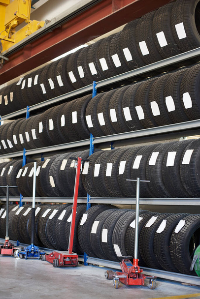 Assorted new automotive road tires showing a variety of tread patterns. Group of tire rubber products for wheel rims with labels at auto repair shop. Concept of car service. - Photo, Image