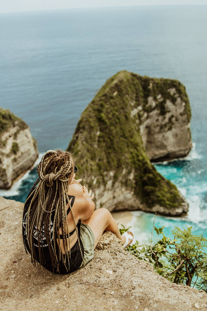 view of woman and Manta Bay or Kelingking Beach on Nusa Penida Island, Bali, Indonesia - Фото, изображение