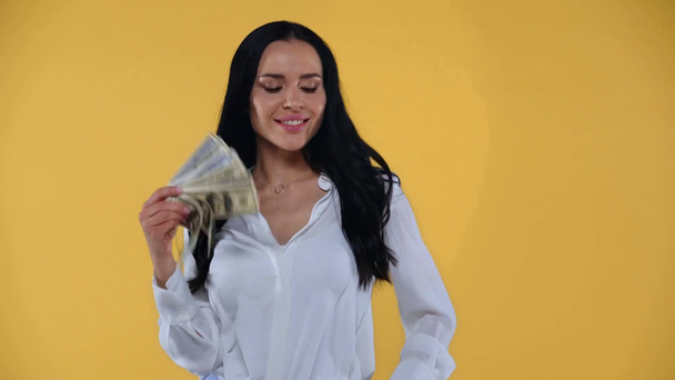 Smiling businesswoman counting dollar banknotes isolated on yellow - Footage, Video