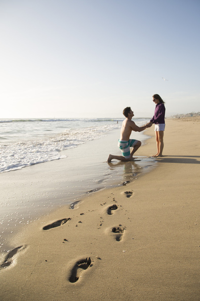 muž zamýšlí přítelkyni na pláži - Fotografie, Obrázek