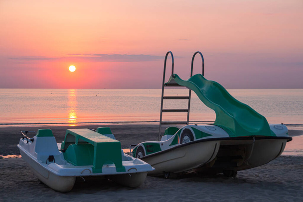 pedál hajók a tengerparton a csodálatos óceán napfelkelte Rivazzurra (Rimini / Olaszország) - Fotó, kép