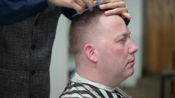 Miesten kampaus parturissa. Lähikuva mestari leikkaamalla mies vaalea tukka leikkuri
 - Materiaali, video
