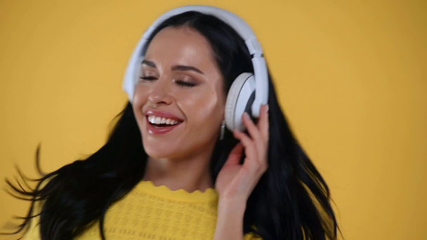 Menina alegre em fones de ouvido dançando isolado no amarelo
 - Filmagem, Vídeo