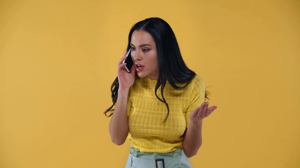 Femme en colère parler et jeter smartphone isolé sur jaune
 - Séquence, vidéo