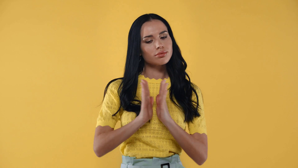 Mooie vrouw met gekruiste vingers weglopen geïsoleerd op geel - Video