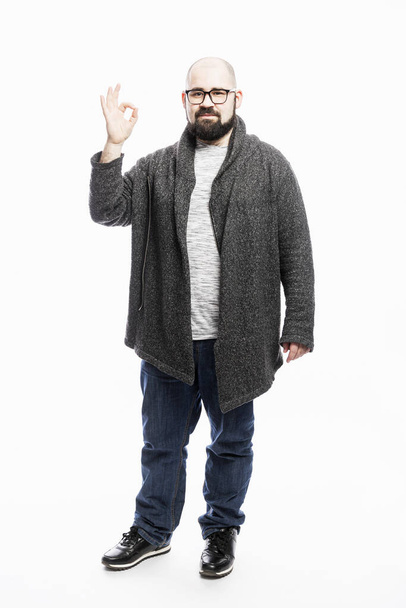 A bald man in jeans holds his hand to his head. Full height. White background. Vertical. - Fotó, kép