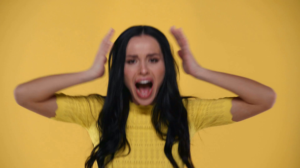Menina chocada gritando com a câmera isolada no amarelo
 - Filmagem, Vídeo