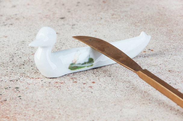 Antique porcelain duck cutlery stand on concrete background. Copy space for text, food photography props. - Photo, Image