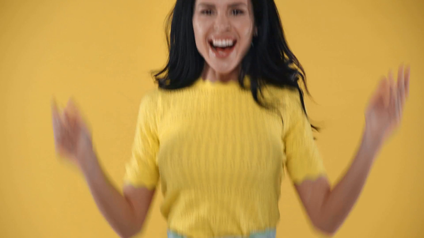Όμορφη σοκαρισμένη γυναίκα χαμογελά στην κάμερα απομονωμένη στο κίτρινο - Πλάνα, βίντεο