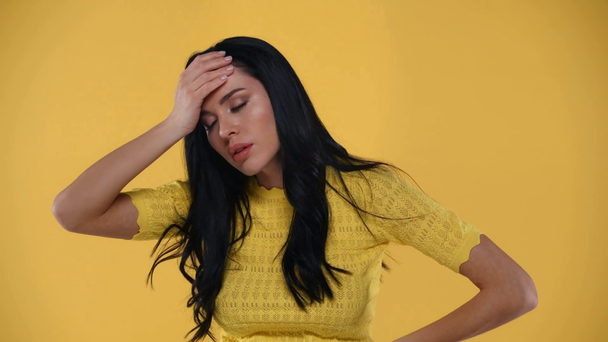 Beautiful woman having migraine isolated on yellow - Footage, Video