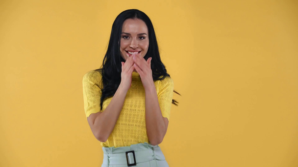 Femme confus souriant à la caméra isolée sur jaune
 - Séquence, vidéo