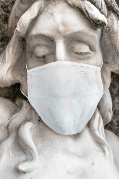Jesus Christ statue with medical mask. COVID-19 in the world. For coronavirus epidemic concepts. - Photo, Image