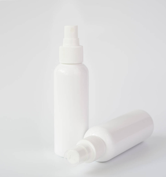White bottles of sanitizer or liquid soap for hand hygiene to protect from corona virus over white background - Foto, Imagem