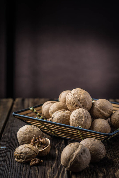 Walnuts on a wooden table and dark background - Φωτογραφία, εικόνα
