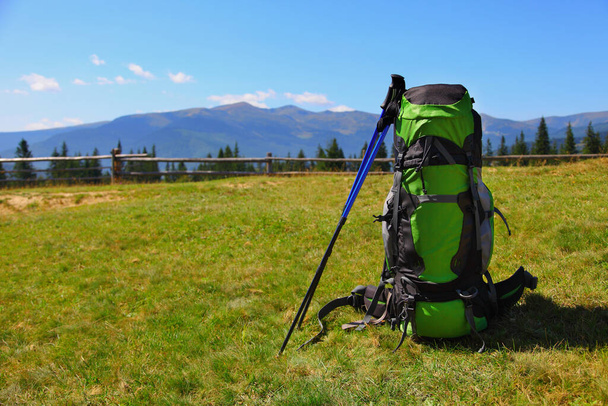 green backpack and trekking poles with mountains background - Photo, Image