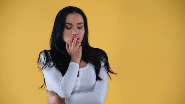 Θλίψη γυναίκα αγγίζοντας το πρόσωπο απομονώνονται σε κίτρινο - Πλάνα, βίντεο