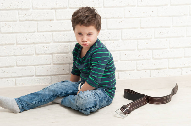 Offended boy and punishment by a belt - Foto, afbeelding