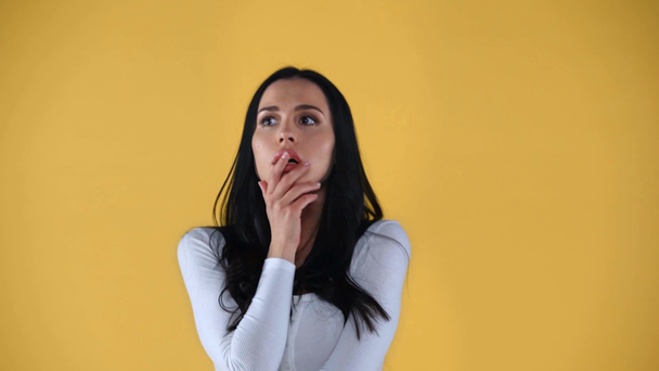 Депрессивная женщина, закрывающая рот и смотрящая на камеру, изолированную на желтый
 - Кадры, видео