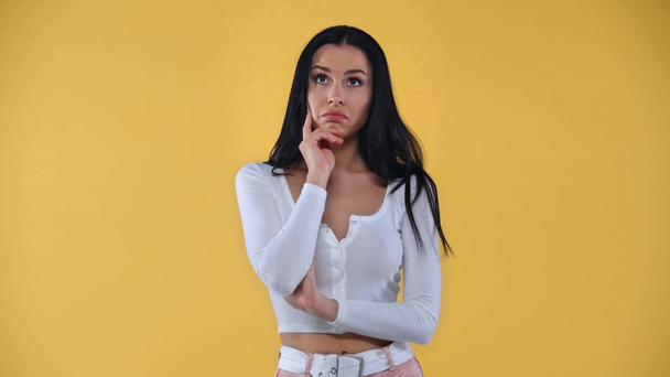 Pensive fille montrant dubium geste à la caméra isolé sur jaune
 - Séquence, vidéo