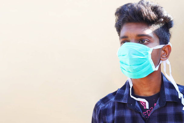 Concetto di consapevolezza. Giovane uomo che indossa maschera igienica facciale contro il virus corona covid 19
. - Foto, immagini