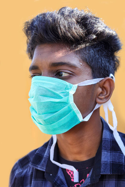 νεαρός άνδρας με προστατευτική μάσκα απομονωμένος σε κίτρινο φόντο - Φωτογραφία, εικόνα