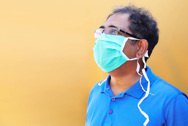 Südasiatischer Mann mit Schutzmaske gegen das Coronavirus covid 19 - Foto, Bild