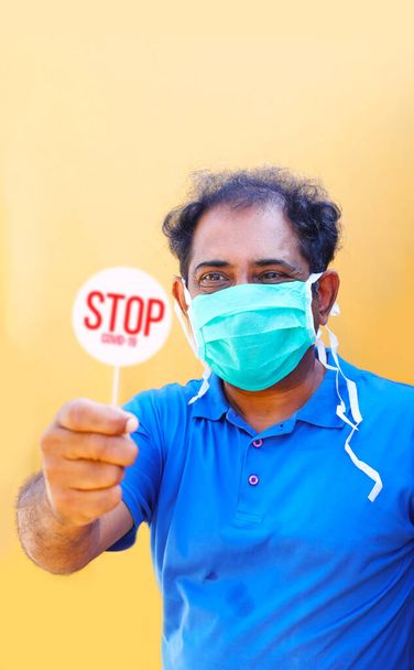 Σταματήστε τη μόλυνση! Υγιής άνθρωπος δείχνει χειρονομία "στοπ". Φωτογραφία του άνδρα με προστατευτική μάσκα - Φωτογραφία, εικόνα