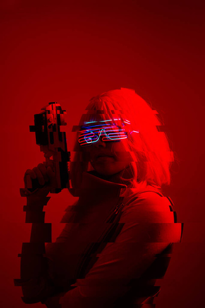 Girl with blaster in the futuristic battle. Concept virtual reality, cyber game. Image with glitch effect. - Φωτογραφία, εικόνα