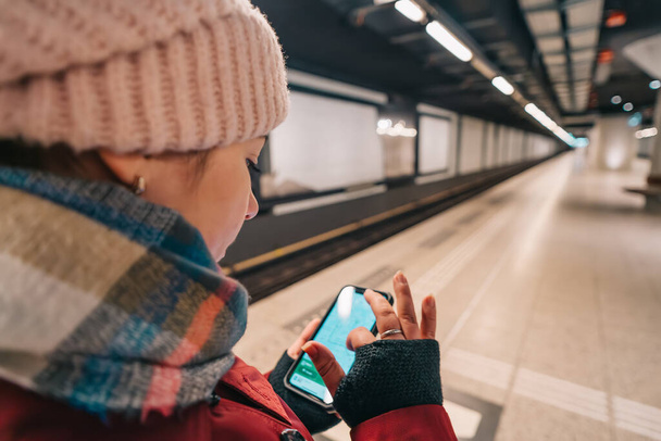 Reisendes Mädchen benutzt Smartphone in U-Bahn, um in U-Bahn zu navigieren und Weg zu finden - Foto, Bild