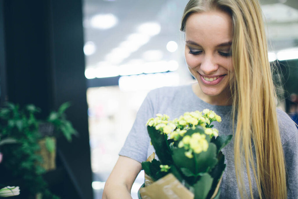 Young woman buying flowers at a garden center - Fotografie, Obrázek