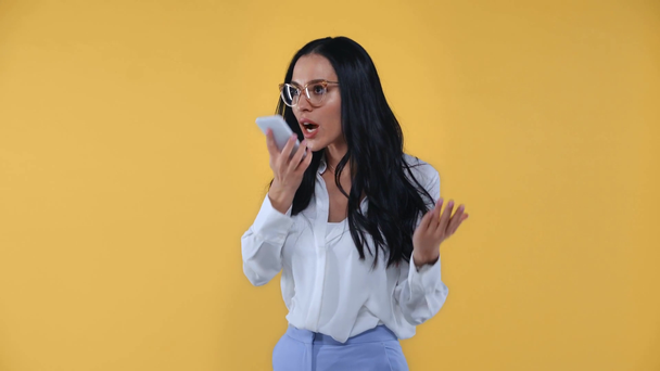Empresária entusiasmada gesticulando e falando no smartphone isolado no amarelo
 - Filmagem, Vídeo