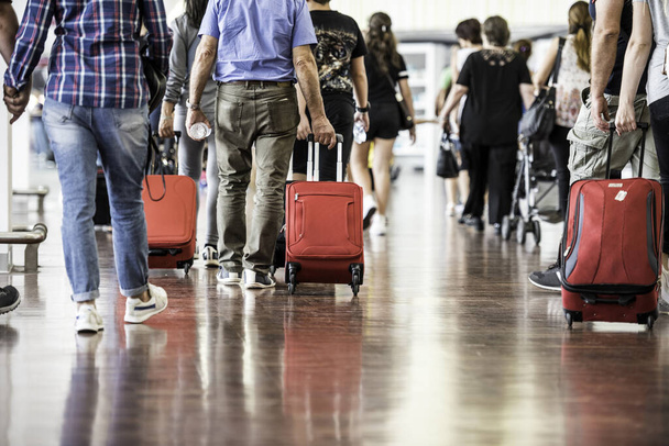 Reisende mit Koffern laufen durch den Flughafen - Foto, Bild