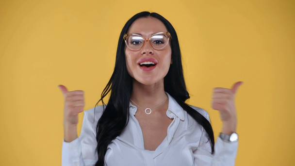 Geschokte zakenvrouw blazen kus en tonen als op camera geïsoleerd op geel - Video