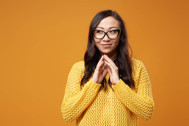 Asian brunette woman in glasses on blank orange background - Foto, Bild