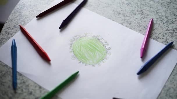dítě v karanténě kreslí koronavirus s barevnými tužkami na bílém listu papíru - Záběry, video