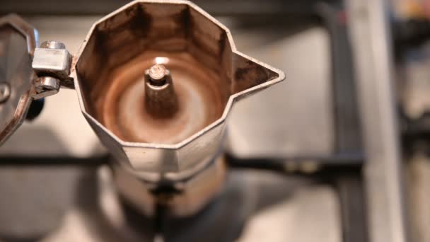 Préparation du café avec la casserole de moka. Gros plan du bec de la cafetière. Dans le fond flou, vous pouvez voir une main qui actionne le bouton de gaz et la flamme bleue s'enflamme
. - Séquence, vidéo