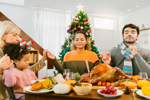 thanksgiving day caucasian family pray together before family dinner with roast turkey and decorating items on wooden table festive ideas concept - Fotó, kép