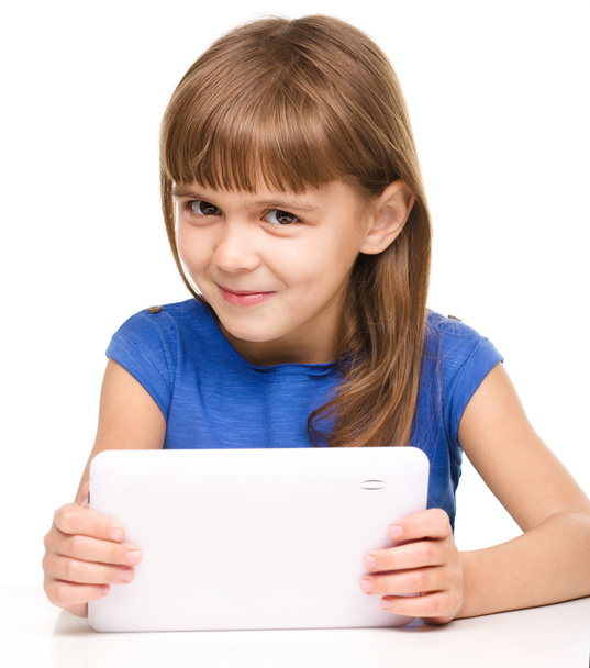 Young cheerful girl is using tablet - Фото, изображение