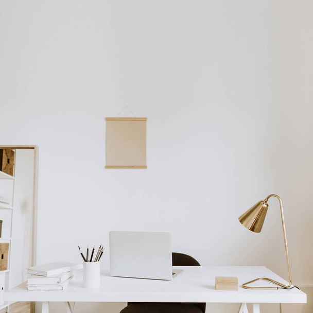 Modern minimal interior design concept. Bright Scandinavian home office desk table workspace with laptop, lamp, books. Business study cabinet. Girl boss studio concept. - 写真・画像