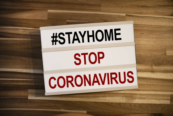 Lightbox or light box covid 19 stay home and stop corona virus on wooden table background - Foto, immagini