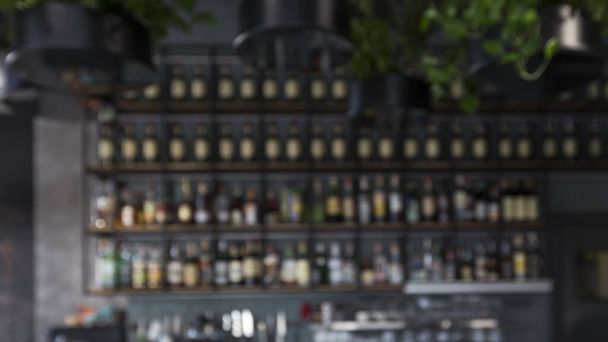 Balcão de bar desfocado com bebidas alcoólicas nas prateleiras, panorama
 - Foto, Imagem